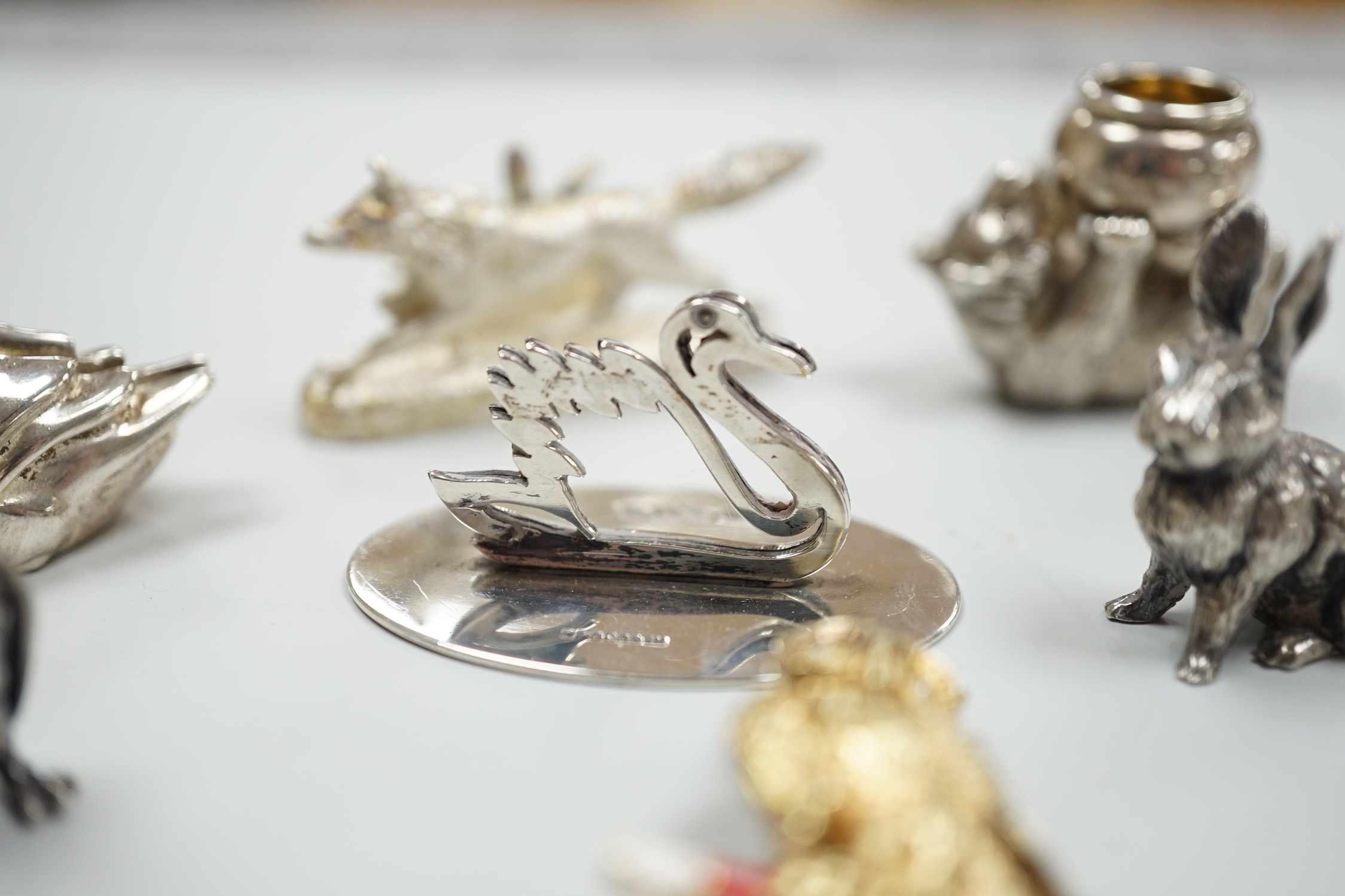 Eight assorted modern silver miniature animal or bird figures including menu holders, including rabbit by Tessiers Ltd, height 27mm, an earlier silver swan menu holder and a silver gilt owl brooch.